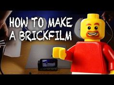 a lego man is making a brickfim with his camera and cell phone in front of him