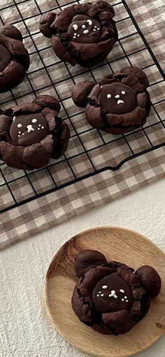 chocolate cookies with white sprinkles are on a plate next to a cooling rack