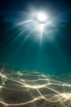 the sun shines brightly over an ocean floor with sand and water bottoming it