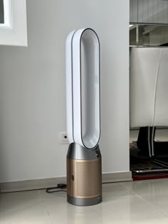 an air purifier sitting on the floor in front of a white wall