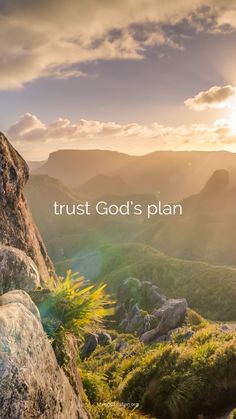 the words trust god's plan are in front of some rocks and grass with mountains in the background