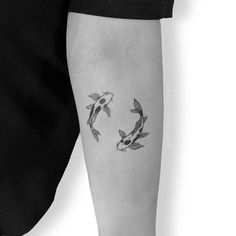 a black and white photo of two koi fish tattoo on the right arm,