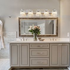 a bathroom with two sinks and a large mirror on the wall over it's vanity