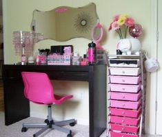 a desk with pink drawers and a mirror on it's wall next to a chair