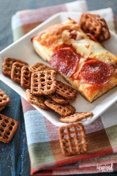 two slices of pepperoni pizza on a plate with waffles and pretzels