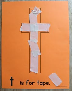 a cross made out of toilet paper on top of an orange sheet of paper that says is for tape