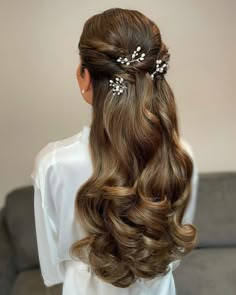 the back of a woman's head with long hair and flowers in her hair