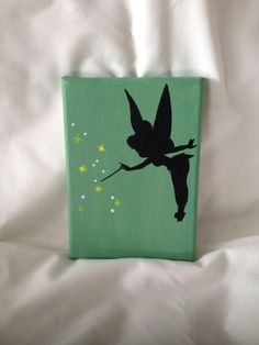 a green box with a black silhouette of a fairy on it