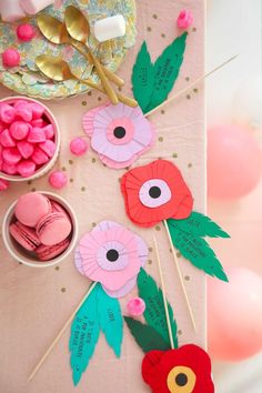 a table topped with paper flowers and candy