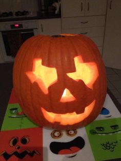 a carved pumpkin sitting on top of a table next to cut out faces and eyes