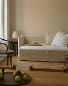 a living room with a couch, chair and table next to a large glass window