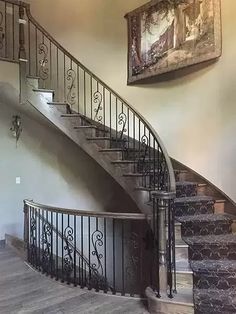 a spiral staircase with wrought iron railing and wood flooring