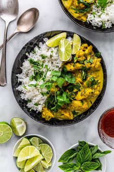 two plates filled with rice, chicken and cilantro on top of a table