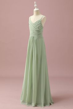 a bridesmaid's dress on a mannequin dummy, in front of a pink background