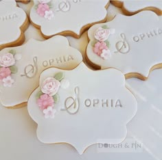 decorated cookies with names and flowers are on a white tablecloth that says ophlia