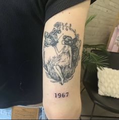 a woman with a tattoo on her arm that reads, 1897 and has an image of two cherubs