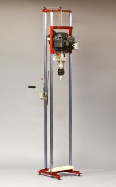 a machine that is sitting on top of a metal stand in front of a gray wall