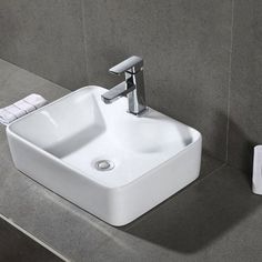 a bathroom sink sitting on top of a counter next to a towel dispenser