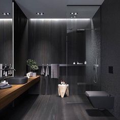 a modern bathroom with black walls and wood flooring is pictured in this image, there are lights on the ceiling