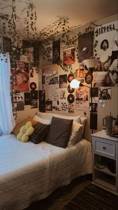 a bed sitting in a bedroom next to a window with pictures on the wall behind it