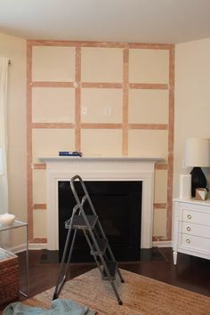 a living room with a fire place and a ladder on the floor in front of it