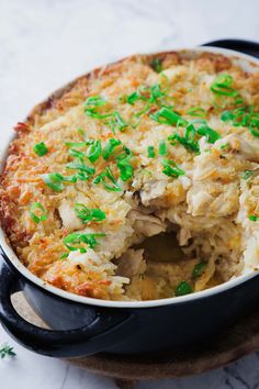 a casserole dish with green onions and meat