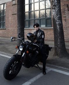 a man is sitting on his motorcycle in the street