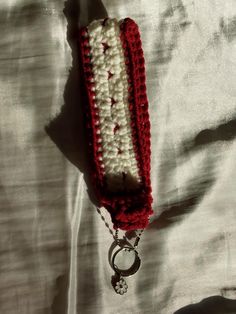 a red and white crocheted keychain on a bed