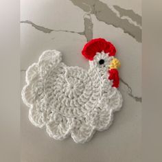 a crocheted chicken ornament on a marble surface