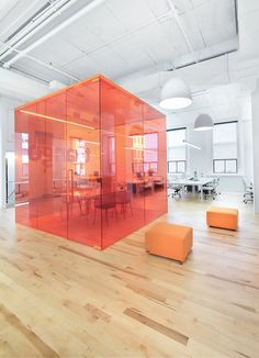 an empty office with orange partitions in the center and wooden floors on both sides