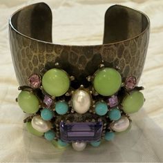 Beautiful And So Rare! Extra Wide Cuff Bracelet Features A Beautiful Floral Embellishment Large Center Amethyst Stone Surrounded By Celadon Cabachon, Turquoise Colored Cabachon, Faux Pearls And Pink Crystal Stone Surface Of Cuff Has Hammered Goldtone And Brass Coloring 2.5” Across Opening 5” Total Circumference Signed Inside Some Peeling Inside/ No Outer Wear! Gorgeous Collectors Piece Designer Cuff Bracelet For Parties, Luxury Jeweled Cuff Bracelet For Formal Occasions, Vintage Jeweled Cuff Bracelet For Formal Occasions, Elegant Green Metal Cuff Bracelet, Elegant Green Cuff Bracelet For Formal Occasions, Elegant Adjustable Jeweled Cuff Bracelet, Floral Embellishment, Wide Cuff Bracelets, Stone Surface