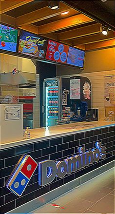 the front counter of a donut shop with neon signs on the wall above it