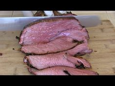 a large piece of meat is being sliced on a cutting board