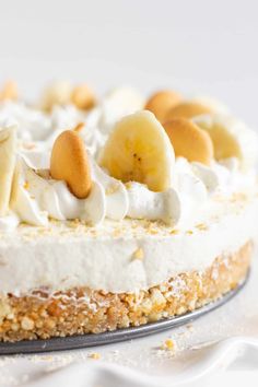 a close up of a cake on a plate with bananas and whipped cream toppings