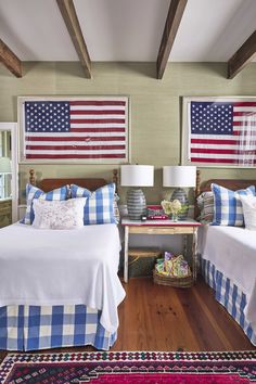 two beds in a room with american flags on the wall