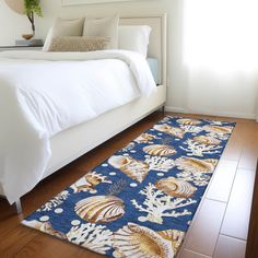 a bedroom with a bed and rug on the floor in front of it that has seashells on it