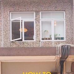 a bench sitting in front of a window next to a wall with windows on it