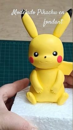 a small yellow pikachu figurine sitting on top of a piece of paper