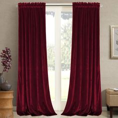 a living room with a large window covered in red curtains