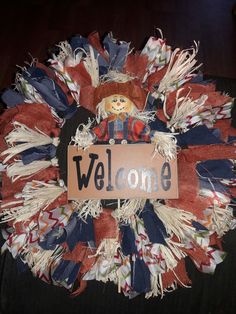 a welcome wreath with a teddy bear on it