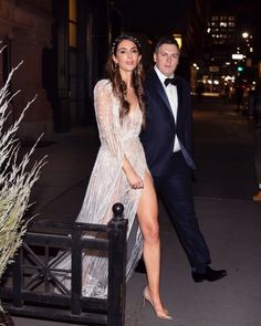 a man in a tuxedo standing next to a woman wearing a white dress