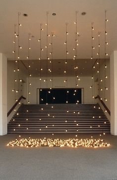 an empty room with stairs and lights hanging from the ceiling over it's carpeted floor