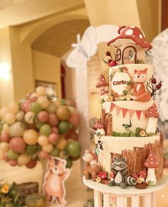 a three tiered cake is decorated with woodland animals, mushrooms and other things on it