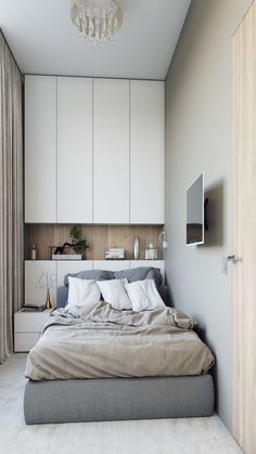 a bedroom with a bed, cabinets and a chandelier hanging from the ceiling