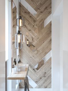 a bathroom with wooden walls and flooring next to a counter top in front of a window