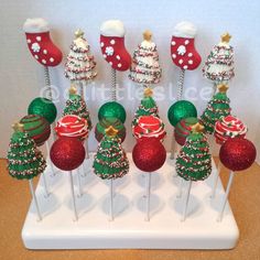 twelve christmas cake pops on a stick with stockings and stocking decorations in the middle