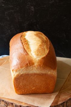 a loaf of bread sitting on top of a piece of paper next to a knife