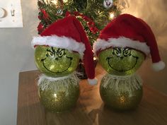 two green christmas balls with faces painted on them