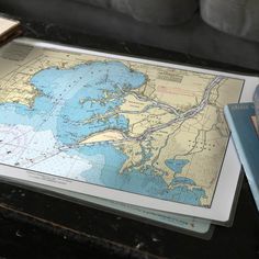 a map and books on a table with a couch in the background