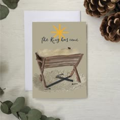 a greeting card with an illustration of a bench and pine cones on the table next to it